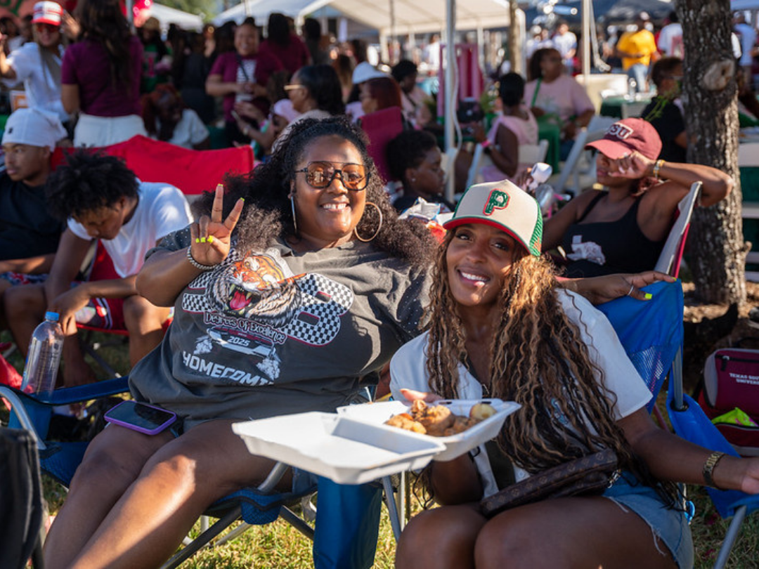 two African American girls sitting at the tailgate